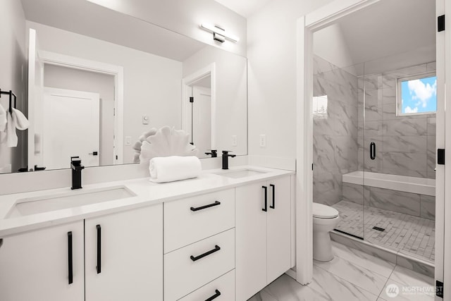 10036B Stone Ave N, Seattle, WA 98133 - full bathroom with marble look tiles, toilet, double vanity, and a marble finish shower