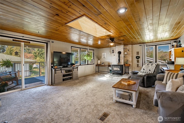 401 British Columbia Ave, Lynden, WA 98264 - living area with wooden ceiling, a wood stove, carpet, and a ceiling fan