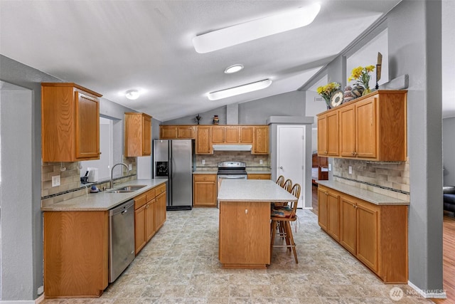 6350 Portal Way Unit 75, Ferndale, WA 98248 - kitchen featuring stainless steel appliances, a sink, vaulted ceiling, under cabinet range hood, and decorative backsplash