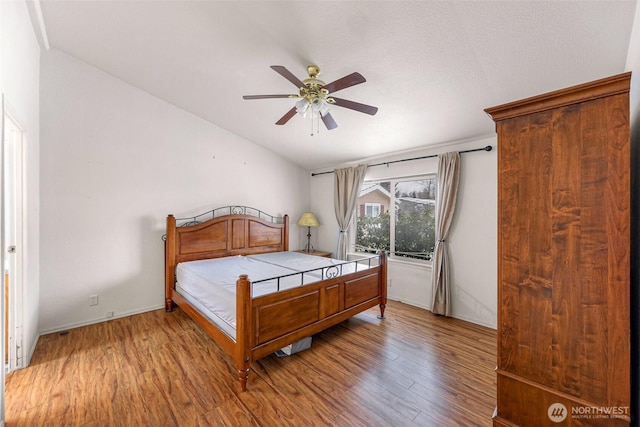 6350 Portal Way Unit 75, Ferndale, WA 98248 - bedroom with wood finished floors, vaulted ceiling, and a ceiling fan