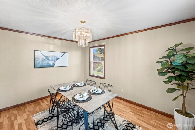 515 120th St S, Tacoma, WA 98444 - dining space featuring light wood finished floors, a chandelier, crown molding, and baseboards