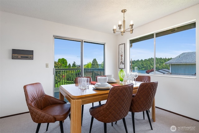 5228 56th Ave S, Seattle, WA 98118 - carpeted dining space featuring a chandelier, baseboards, and a textured ceiling