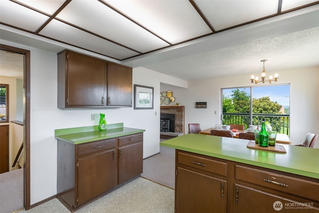5228 56th Ave S, Seattle, WA 98118 - kitchen with a fireplace with raised hearth, plenty of natural light, a chandelier, and open floor plan