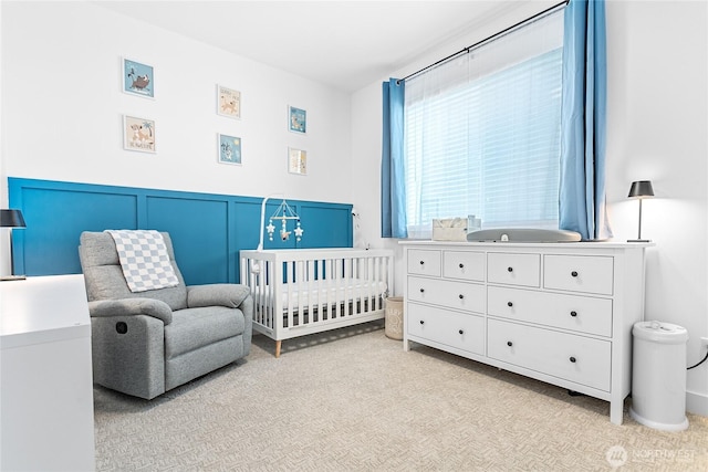 2016 Steelhead Way, Lynden, WA 98264 - bedroom featuring a crib, light carpet, wainscoting, and a decorative wall
