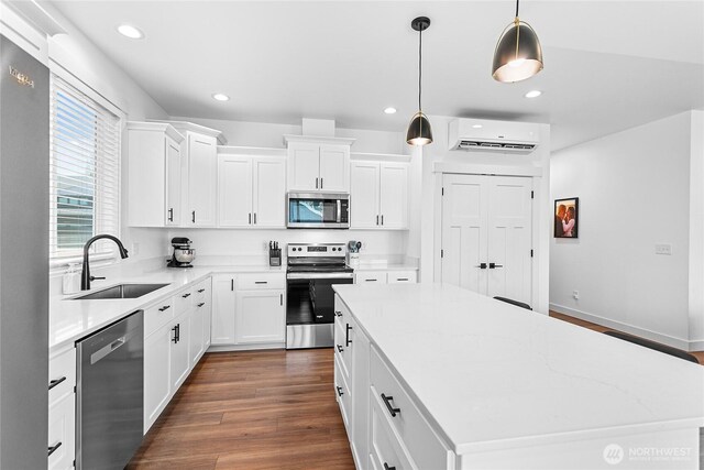 2016 Steelhead Way, Lynden, WA 98264 - kitchen with stainless steel appliances, a sink, a wall unit AC, a kitchen island, and recessed lighting