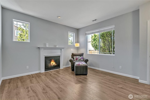 28140 239th Ave SE, Maple Valley, WA 98038 - sitting room with wood finished floors, a glass covered fireplace, and healthy amount of natural light