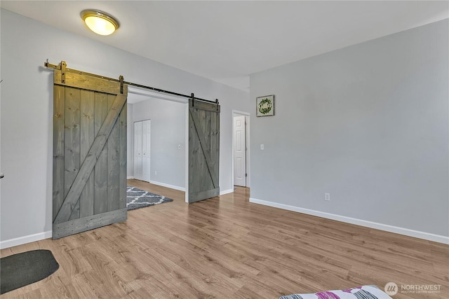 28140 239th Ave SE, Maple Valley, WA 98038 - unfurnished bedroom with a barn door and wood finished floors