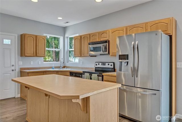 28140 239th Ave SE, Maple Valley, WA 98038 - kitchen with stainless steel appliances, light countertops, light wood finished floors, a center island, and a breakfast bar area