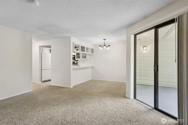 12515 NE 116th St Unit B23, Kirkland, WA 98034 - unfurnished room featuring a chandelier, carpet, a textured ceiling, and baseboards