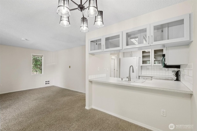 12515 NE 116th St Unit B23, Kirkland, WA 98034 - kitchen with freestanding refrigerator, carpet, a sink, backsplash, and glass insert cabinets