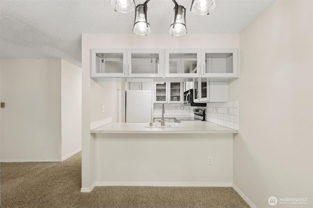 12515 NE 116th St Unit B23, Kirkland, WA 98034 - kitchen featuring appliances with stainless steel finishes, a sink, carpet, a textured ceiling, and tasteful backsplash