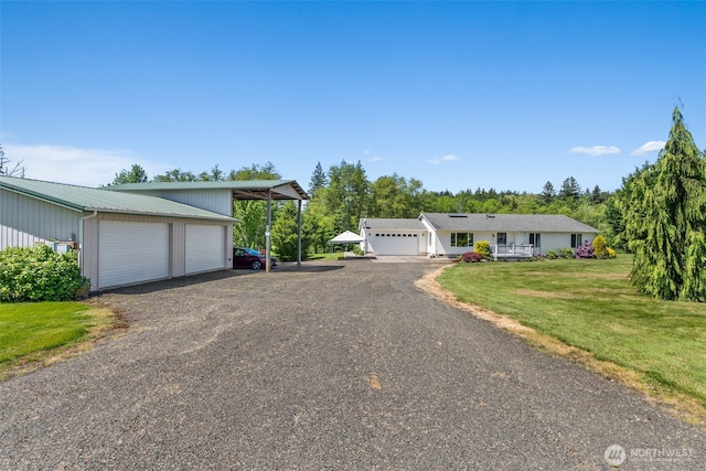 401 Huntting Rd, Silver Creek, WA 98585 - view of front of home with a front lawn, a garage, gravel driveway, metal roof, and an outdoor structure