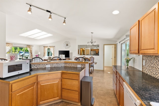 401 Huntting Rd, Silver Creek, WA 98585 - kitchen featuring white appliances, lofted ceiling, dark countertops, a skylight, and decorative backsplash