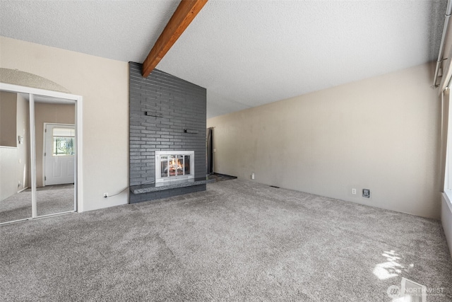 11401 69th Pl S, Seattle, WA 98178 - unfurnished living room featuring beam ceiling, carpet, a fireplace, and a textured ceiling