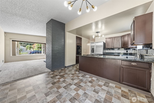 11401 69th Pl S, Seattle, WA 98178 - kitchen with a chandelier, open floor plan, appliances with stainless steel finishes, a peninsula, and dark brown cabinets