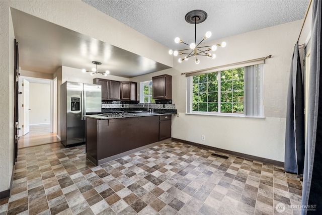 11401 69th Pl S, Seattle, WA 98178 - kitchen with stainless steel refrigerator with ice dispenser, a chandelier, dark brown cabinetry, dark countertops, and baseboards
