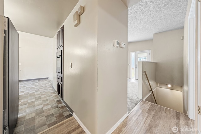 11401 69th Pl S, Seattle, WA 98178 - hallway with an upstairs landing, a textured ceiling, baseboards, and wood finished floors