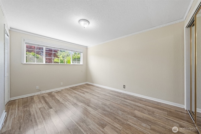 11401 69th Pl S, Seattle, WA 98178 - unfurnished bedroom featuring ornamental molding, wood finished floors, a textured ceiling, baseboards, and a closet