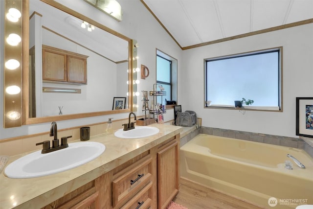 23708 Locust Way Unit 8B, Bothell, WA 98021 - bathroom with vaulted ceiling, ornamental molding, a bath, double vanity, and wood finished floors