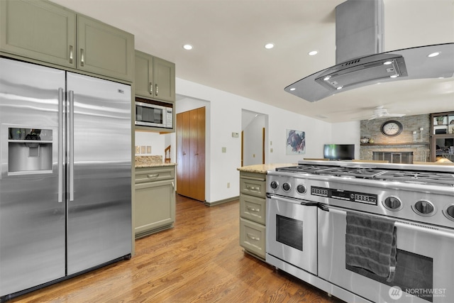 14937 104th Ave NE, Bothell, WA 98011 - kitchen with high end appliances, green cabinets, island range hood, light wood-style floors, and recessed lighting