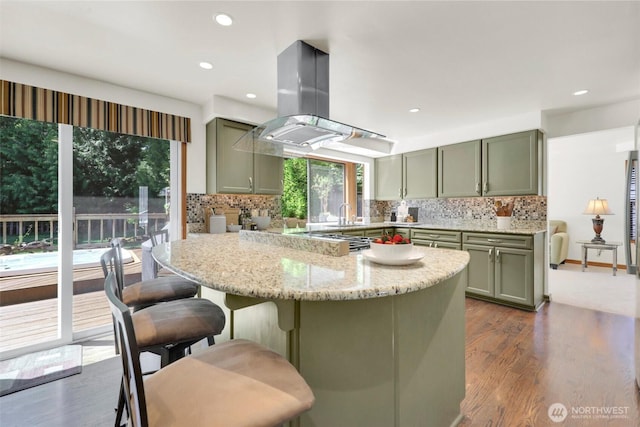 14937 104th Ave NE, Bothell, WA 98011 - kitchen featuring island exhaust hood, dark wood finished floors, backsplash, light stone countertops, and recessed lighting