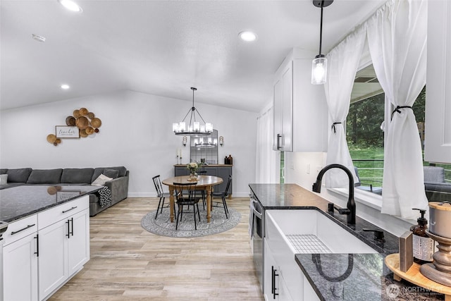 23059 Ida Ln, Sedro Woolley, WA 98284 - kitchen featuring vaulted ceiling, white cabinets, light wood finished floors, dark stone counters, and a chandelier