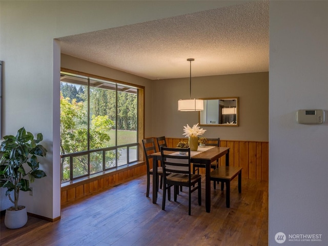 52 W Pheasant Ln, Sequim, WA 98382 - dining space featuring wood finished floors, a textured ceiling, wooden walls, and wainscoting