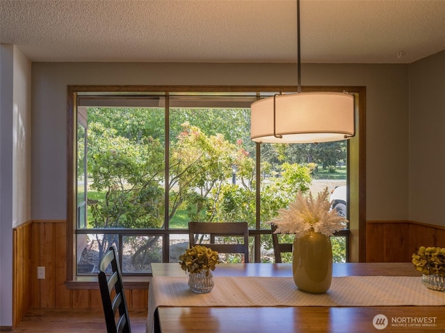 52 W Pheasant Ln, Sequim, WA 98382 - dining room with wainscoting, wood walls, plenty of natural light, wood finished floors, and a textured ceiling
