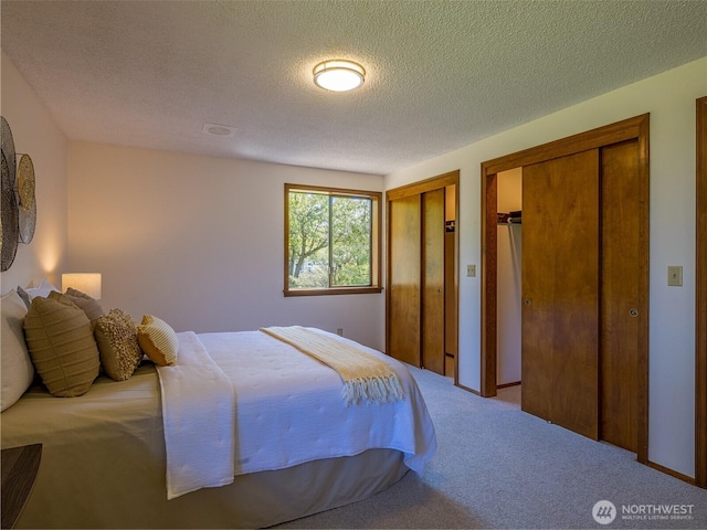 52 W Pheasant Ln, Sequim, WA 98382 - carpeted bedroom featuring multiple closets and a textured ceiling