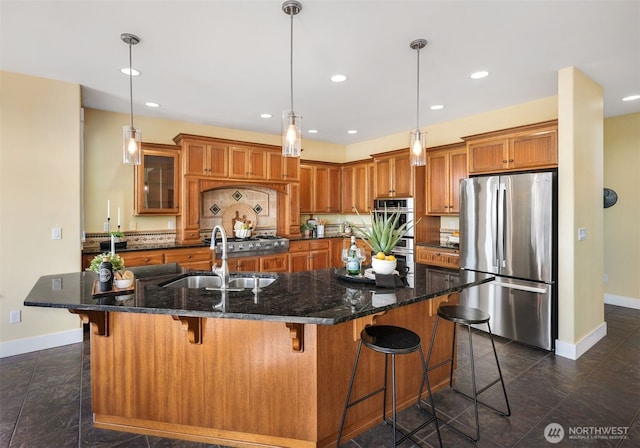 884 Saratoga Way, Camano Island, WA 98282 - kitchen featuring appliances with stainless steel finishes, brown cabinets, baseboards, a sink, and a large island with sink