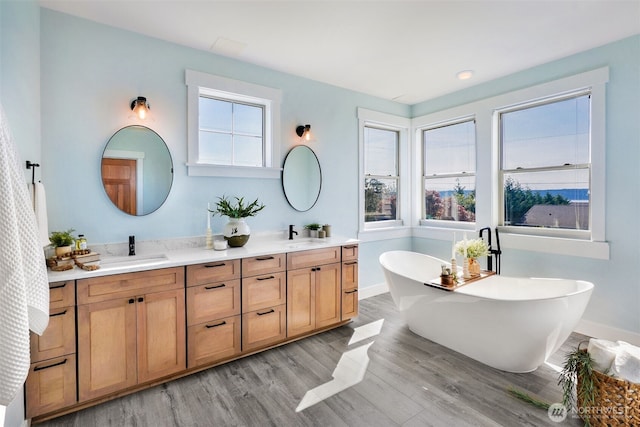 884 Saratoga Way, Camano Island, WA 98282 - full bathroom with wood finished floors, double vanity, a freestanding bath, and baseboards