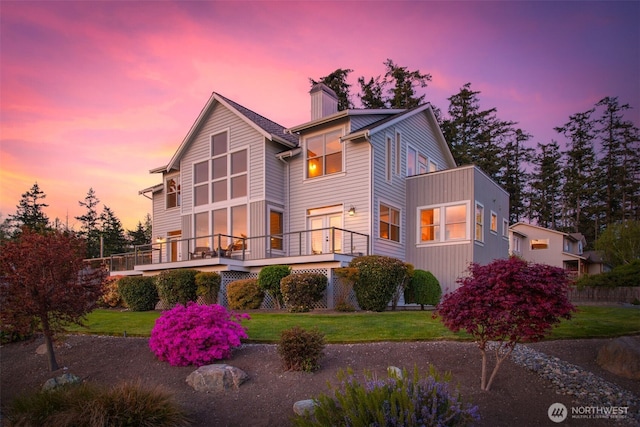 884 Saratoga Way, Camano Island, WA 98282 - back of house at dusk with a chimney, a yard, and a wooden deck
