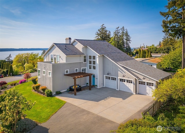 884 Saratoga Way, Camano Island, WA 98282 - contemporary home with driveway, an attached garage, a front lawn, a chimney, and a water view