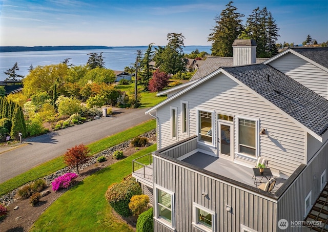 884 Saratoga Way, Camano Island, WA 98282 - back of property with a water view, a balcony, a lawn, a chimney, and a shingled roof