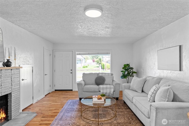 659 NW New York Ave, Chehalis, WA 98532 - living room with a brick fireplace, light wood-style floors, and a textured ceiling