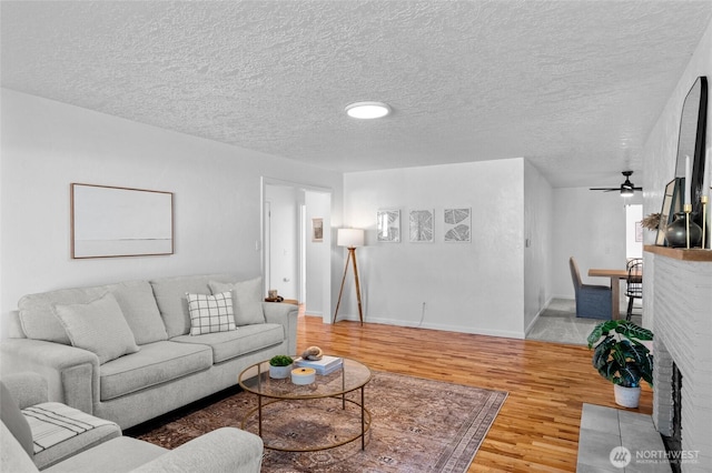 659 NW New York Ave, Chehalis, WA 98532 - living room featuring wood finished floors, a textured ceiling, baseboards, and a ceiling fan