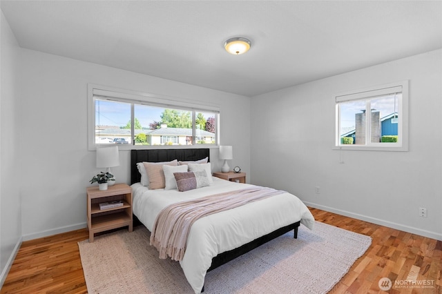 659 NW New York Ave, Chehalis, WA 98532 - bedroom featuring multiple windows, baseboards, and light wood-style floors