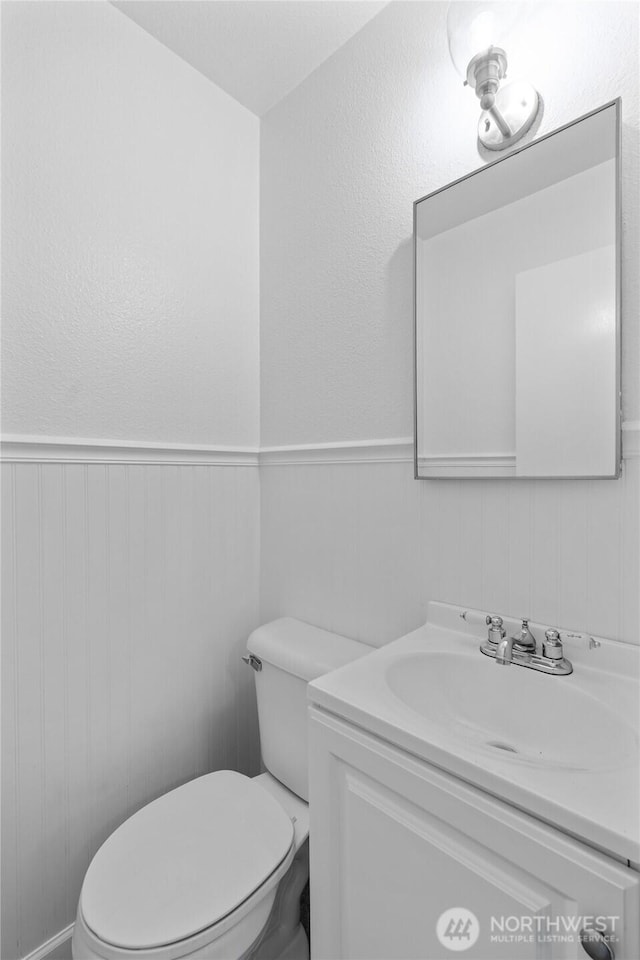 659 NW New York Ave, Chehalis, WA 98532 - bathroom with vanity, toilet, and a wainscoted wall