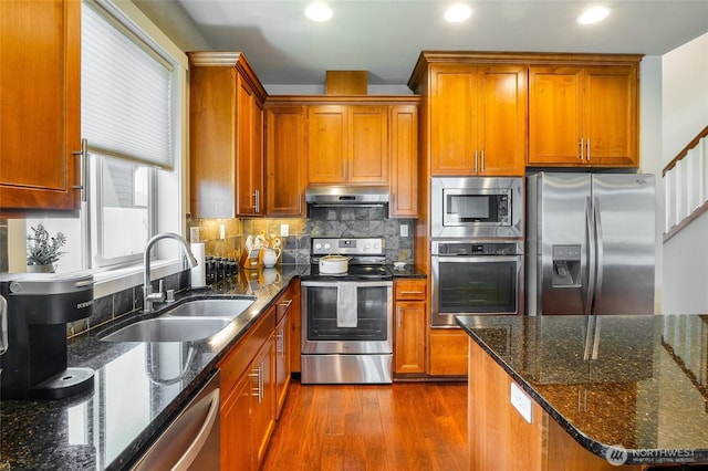 4709 W Fox St, Moses Lake, WA 98837 - kitchen with appliances with stainless steel finishes, a sink, under cabinet range hood, dark wood finished floors, and backsplash