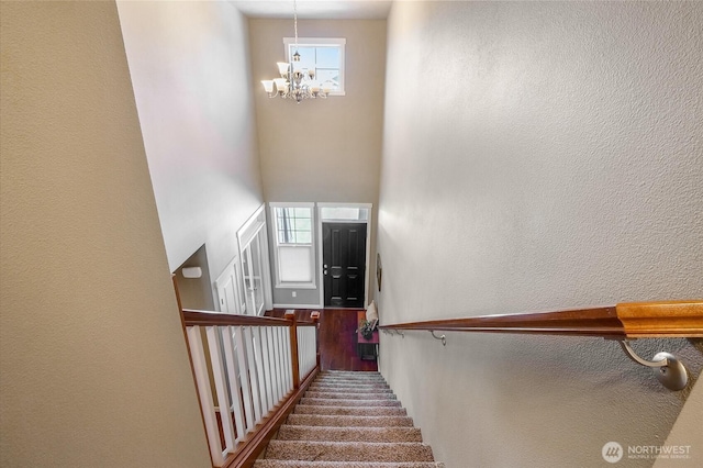 4709 W Fox St, Moses Lake, WA 98837 - stairs featuring a chandelier, a towering ceiling, a textured wall, and carpet floors