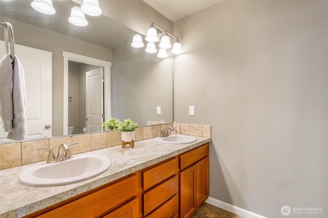 4709 W Fox St, Moses Lake, WA 98837 - full bathroom with double vanity, toilet, tile patterned flooring, and baseboards