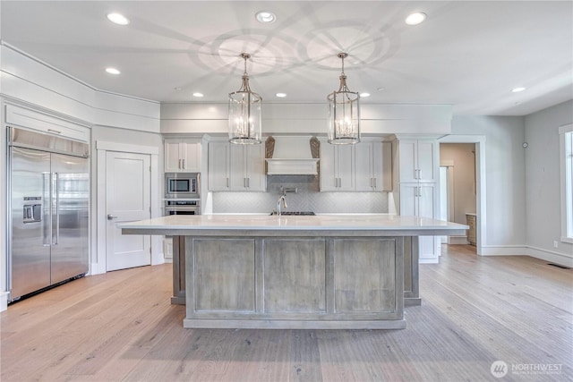 4942 Hurst Landing Rd, Rock Island, WA 98850 - kitchen with built in appliances, light countertops, recessed lighting, a large island with sink, and backsplash