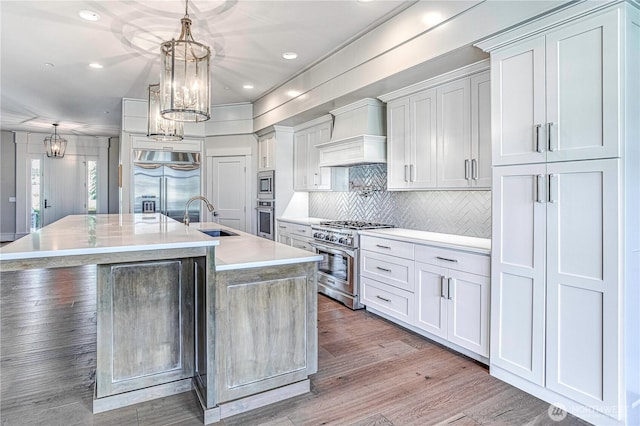 4942 Hurst Landing Rd, Rock Island, WA 98850 - kitchen featuring built in appliances, a sink, a spacious island, tasteful backsplash, and light countertops