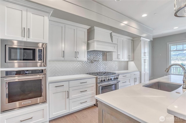 4942 Hurst Landing Rd, Rock Island, WA 98850 - kitchen with stainless steel appliances, a sink, premium range hood, light countertops, and recessed lighting