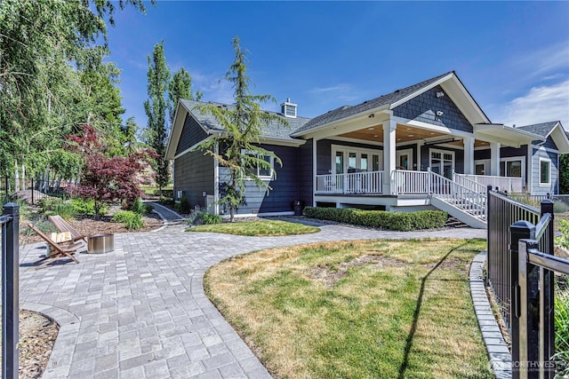 4942 Hurst Landing Rd, Rock Island, WA 98850 - ranch-style home with covered porch, roof with shingles, a front lawn, a patio, and a chimney