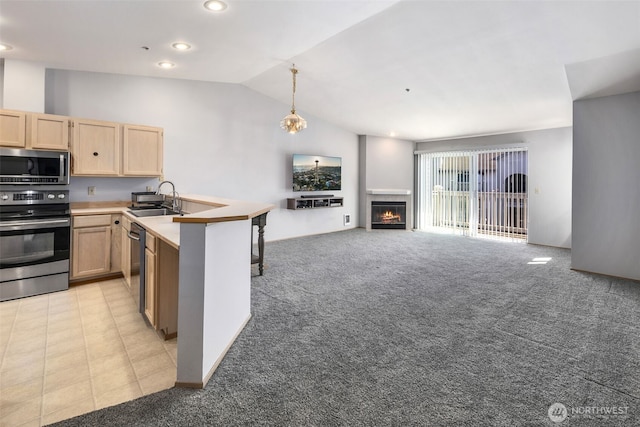 11325 19th Ave SE Unit C309, Everett, WA 98208 - kitchen with stainless steel appliances, light brown cabinets, a peninsula, a sink, and light colored carpet