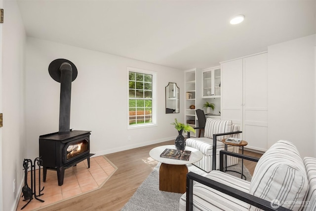 8021 NE Sandpiper Ln, Bainbridge Island, WA 98110 - living area featuring light wood-type flooring, a wood stove, and baseboards