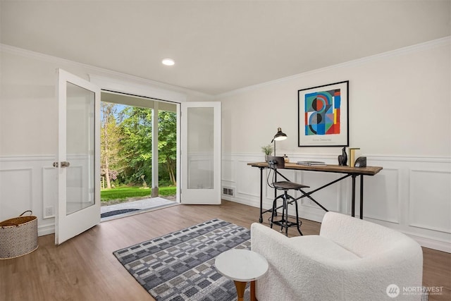8021 NE Sandpiper Ln, Bainbridge Island, WA 98110 - sitting room featuring a decorative wall, french doors, wainscoting, ornamental molding, and wood finished floors