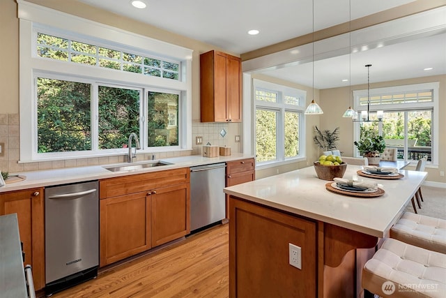 412 15th Ave, Kirkland, WA 98033 - kitchen with stainless steel dishwasher, a sink, brown cabinetry, a kitchen bar, and recessed lighting
