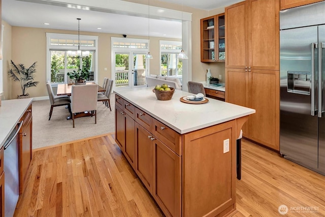 412 15th Ave, Kirkland, WA 98033 - kitchen featuring stainless steel appliances, light wood-type flooring, brown cabinets, glass insert cabinets, and light countertops